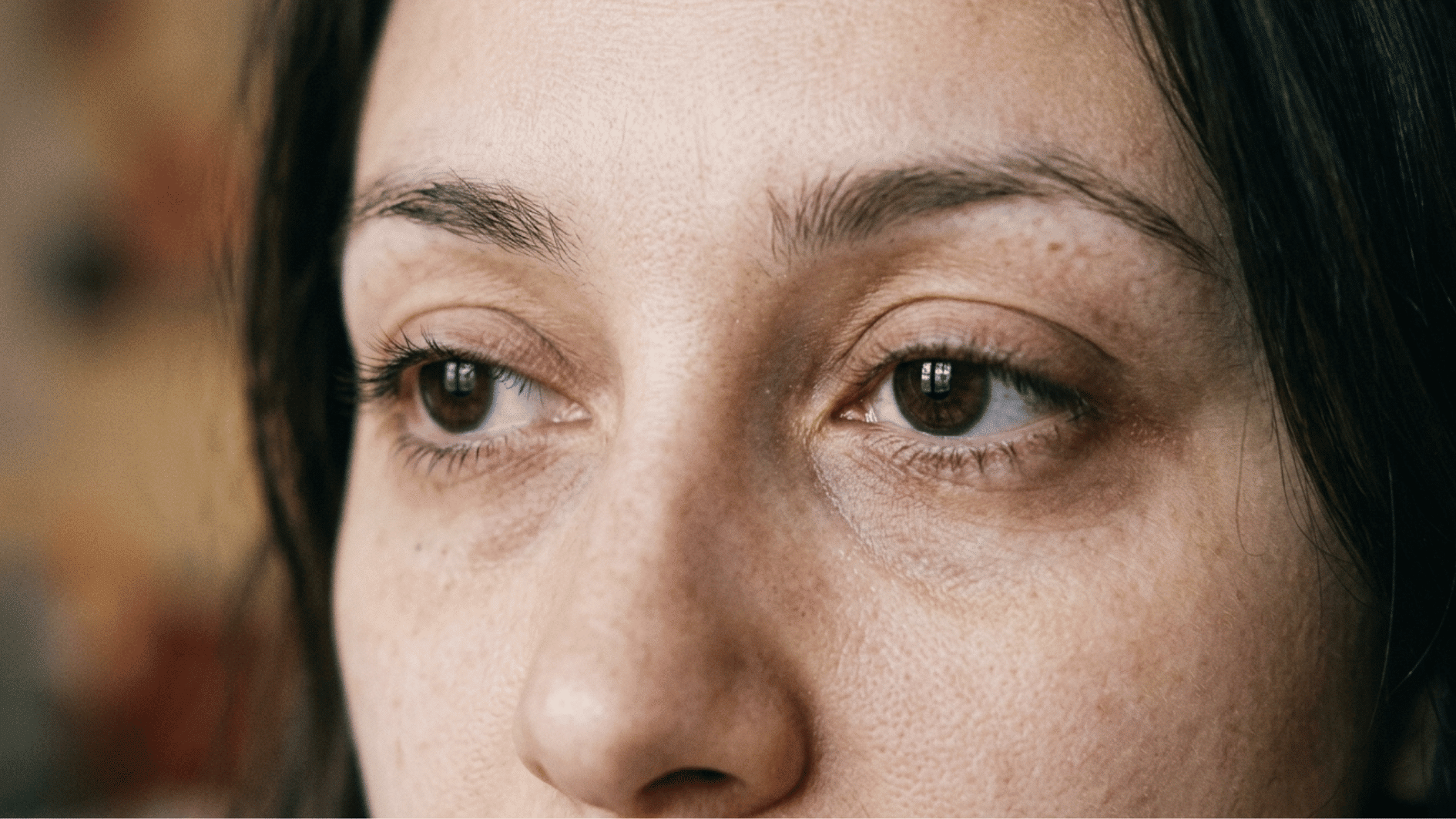 a human face focusing on eyes, showing subtle tiredness and emotional fatigue