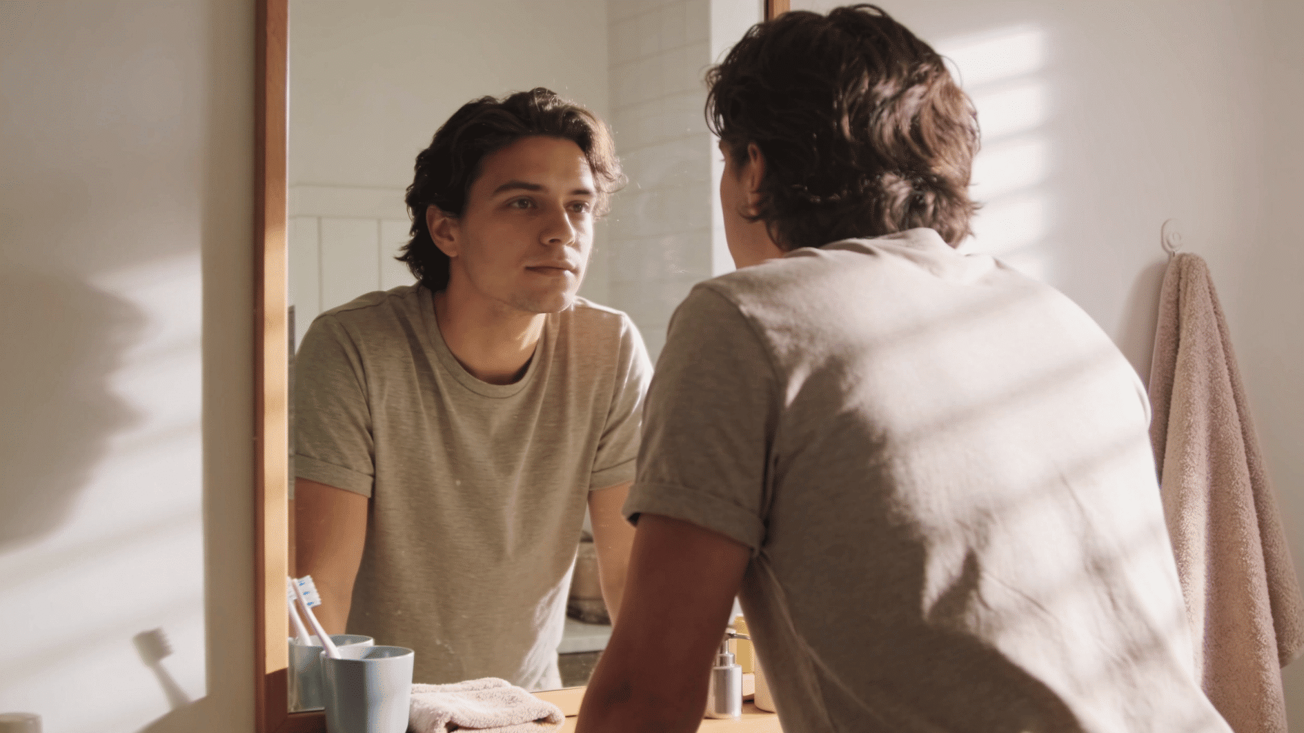 man looking calmly at his reflection in the mirror, reflecting confidence after healing