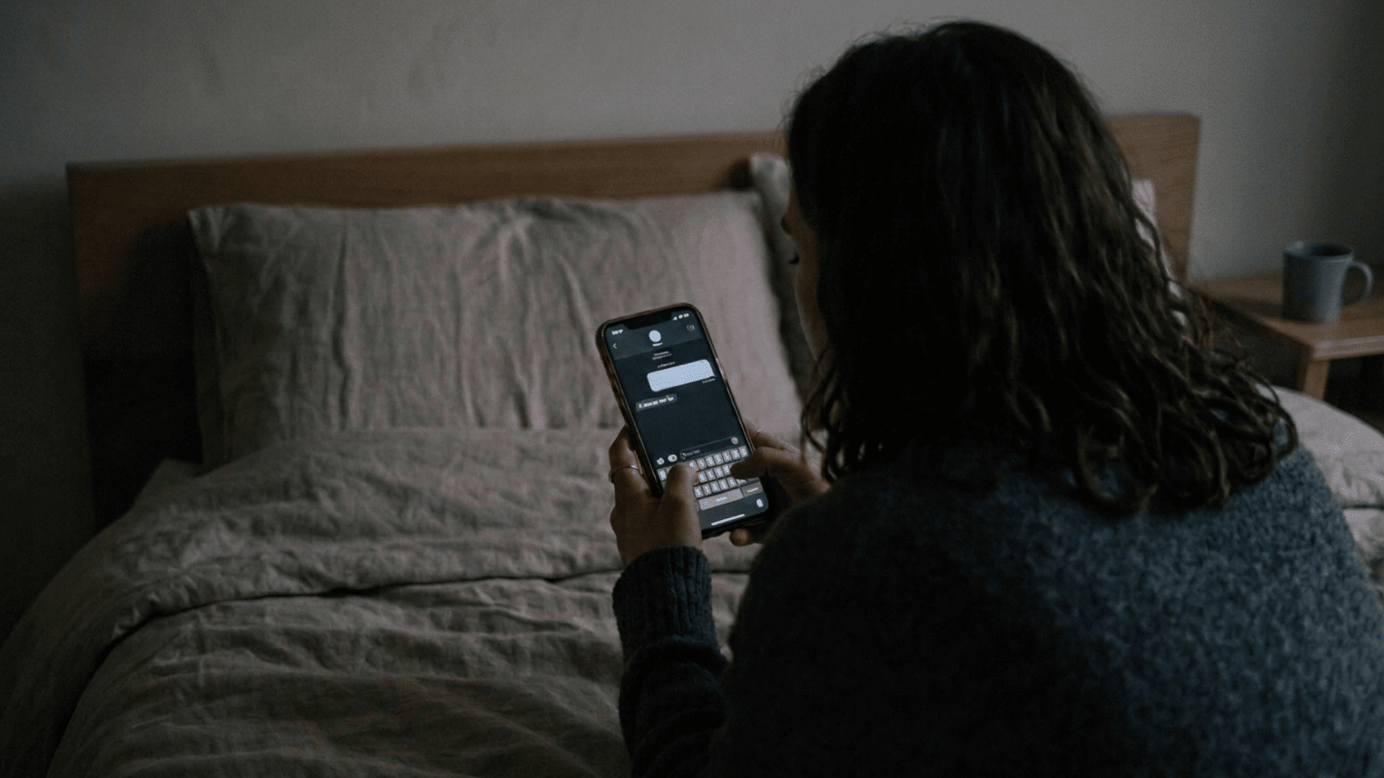 person checking phone messages at night while feeling anxious about a new relationship